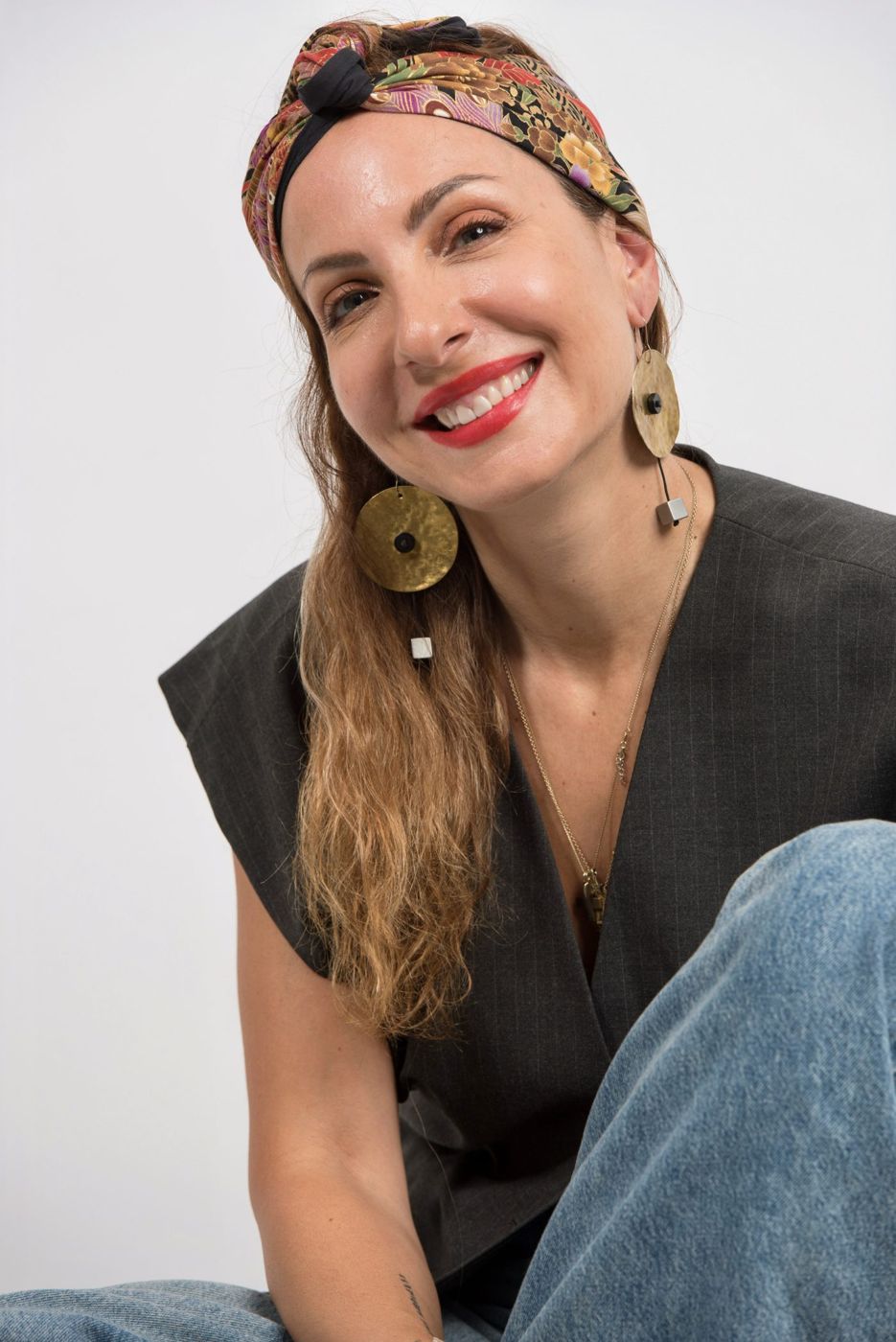 Sophia smiling, with a scarf in her hair and gold earrings
